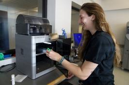 female student removing item from a 3D printer in the CEPS Makerspace